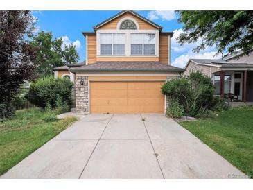 Inviting home featuring an attached two-car garage and a well-maintained lawn at 2786 S Cathay Way, Aurora, CO 80013