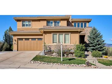 Two-story home featuring a tan stucco and stone facade with an attached two-car garage at 10751 Manorstone Dr, Highlands Ranch, CO 80126
