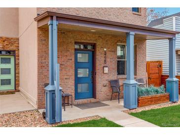 Charming front porch with blue columns, a blue door, brick exterior, and inviting seating area at 3720 Jason St, Denver, CO 80211