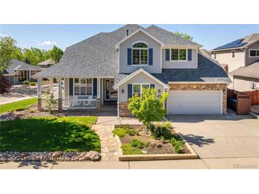 Charming two-story home featuring a stone facade, covered porch, and well-manicured lawn at 1996 Clipper Dr, Lafayette, CO 80026