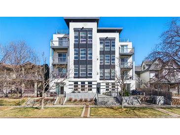 Modern condo building with sleek design, balconies, and professional landscaping against a bright blue sky at 1738 N Franklin St # 2B, Denver, CO 80218