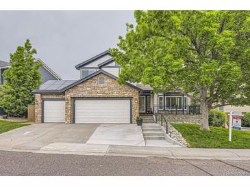 Charming home featuring stone accents, three-car garage, and inviting curb appeal at 8657 Aberdeen Cir, Highlands Ranch, CO 80130