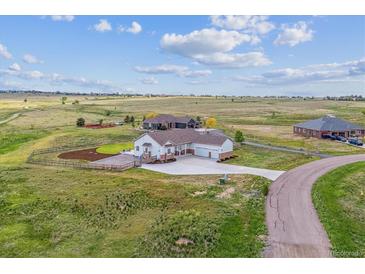 Expansive home with a three-car garage nestled in a vast, open landscape with a long drive at 527 Antelope E Dr, Bennett, CO 80102