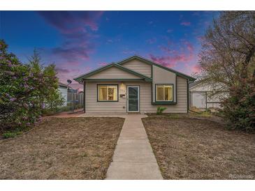 Charming single-story home with a well-manicured lawn and inviting front porch under a beautiful sunset sky at 124 3Rd St, Fort Lupton, CO 80621