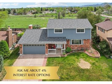 Charming two-story home features a brick facade, a well-manicured lawn, and an attached garage at 8732 W Arbor Ave, Littleton, CO 80123