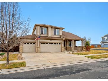 Charming two-story home with a three-car garage and a welcoming front porch at 10741 Idalia Way, Commerce City, CO 80022