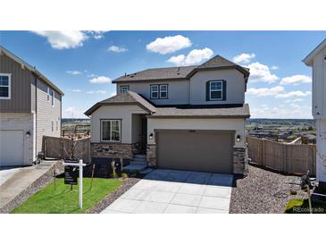 Beautiful two-story home showcasing stone accents, a well-manicured lawn, and an attached two-car garage at 13446 Amber Sky St, Parker, CO 80134