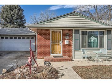 Charming home featuring brick accents, a well-manicured lawn, and an attached garage at 7005 S Ash Cir, Centennial, CO 80122