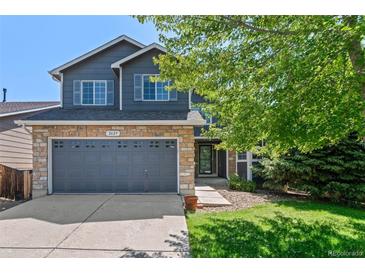 Charming two-story home features a stone facade, gray siding, a two-car garage and a well-manicured lawn at 2629 Wisteria Dr, Erie, CO 80516