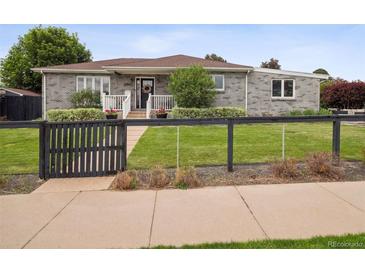 Charming gray brick home with well-manicured lawn, inviting front porch, and a decorative sunflower wreath at 2945 E 26Th Avenue Pkwy, Denver, CO 80205