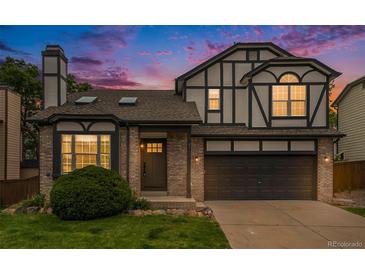 Two-story house with a dark brown garage door and landscaped yard at 8362 White Cloud St, Highlands Ranch, CO 80126