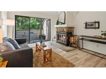 Inviting living room with a stone fireplace, sliding glass doors to balcony, and stylish decor at 7379 S Gore Range Rd # 304, Littleton, CO 80127