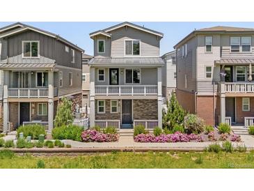 Charming three-story home with a balcony and colorful landscaping at 12714 E Dickenson Ave, Aurora, CO 80014