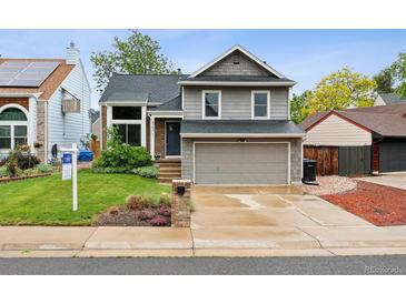 Charming two-story home with a well-maintained lawn, inviting entrance and two car garage at 6342 Marshall St, Arvada, CO 80003