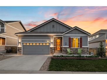 Charming single-story home with gray siding, stone accents, and a well-manicured front yard at 8048 Grady Cir, Castle Rock, CO 80108