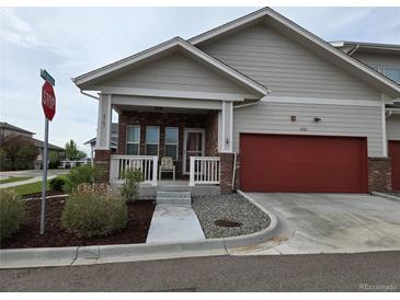 Charming exterior with a red garage door, covered porch and well maintained landscaping at 6761 Meade Cir, Westminster, CO 80030