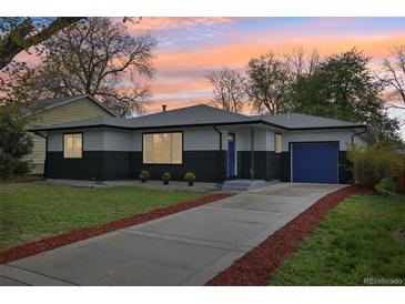 Charming home with a blue door and garage in front of a beautiful lawn and inviting driveway at 7780 Osceola St, Westminster, CO 80030