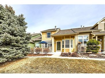 Charming exterior of a multi-level home with stone accents and a well-manicured lawn at 1104 Rumbling Sky Pl, Castle Rock, CO 80108