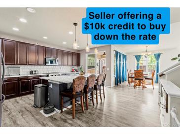 Bright kitchen with island seating, stainless appliances, granite counters, and a $10k rate reduction incentive at 7018 E 123Rd Pl, Thornton, CO 80602