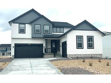 Modern two-story home featuring white siding, black trim, and a two-car garage at 39836 Floyd St, Elizabeth, CO 80107