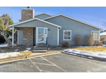 Gray exterior of a charming ranch-style home with stone accents and landscaping at 8471 Everett Way # A, Arvada, CO 80005