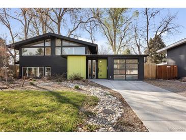 Striking modern home with sleek black siding, large windows, and a bright green accent wall at 1345 S Ivy Way, Denver, CO 80224