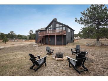Inviting backyard with a fire pit surrounded by Adirondack chairs, perfect for outdoor relaxation and entertaining at 28364 Tresine Dr, Evergreen, CO 80439