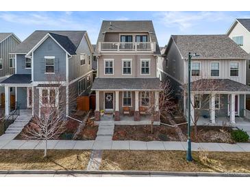 Charming two-story home with a cozy front porch and balcony, perfect for relaxing outdoors at 11346 E 27Th Ave, Denver, CO 80238