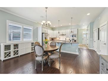 Bright kitchen features stainless steel appliances, white cabinets, and hardwood floors at 11346 E 27Th Ave, Denver, CO 80238