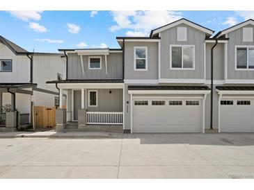 Charming townhome with a two-car garage and inviting front porch with classic white railings at 4024 Upham St, Wheat Ridge, CO 80033