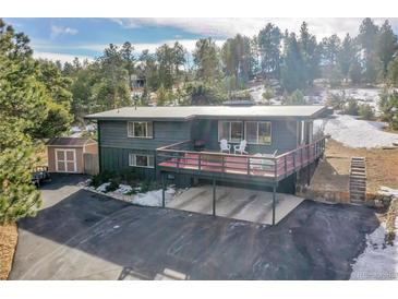 Stylish two-story home with large deck, ample parking, and storage shed surrounded by mature trees at 29304 Thimbleberry Ln, Evergreen, CO 80439