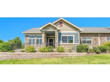 Charming home featuring manicured landscaping, a stone accent wall, and inviting curb appeal at 12444 Madison Way, Thornton, CO 80241