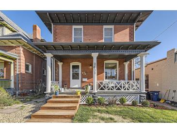 Charming two-story brick home featuring a welcoming front porch with classic white columns and inviting curb appeal at 2631 W 34Th Ave, Denver, CO 80211