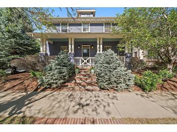 Inviting two-story home featuring a charming front porch and well-maintained landscaping at 2461 Spruce St, Denver, CO 80238