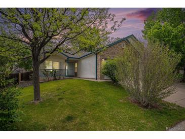 Charming single-Gathering home featuring a well-maintained lawn and mature trees in a peaceful neighborhood at 5214 S Tibet St, Aurora, CO 80015