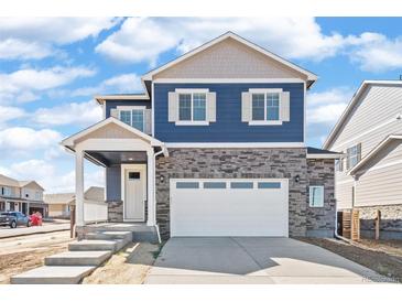 Charming two-story home with blue siding, stone accents, a covered porch, and a two-car garage at 18120 Dandy Brush Ln, Parker, CO 80134