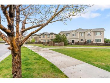 Exterior townhome view showing sidewalk and manicured lawn at 12973 Grant E Cir # A, Thornton, CO 80241