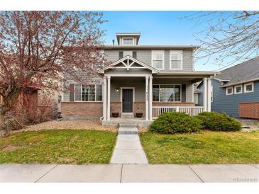 Charming two-story home with a welcoming front porch and well-manicured lawn at 11022 Newark St, Commerce City, CO 80640