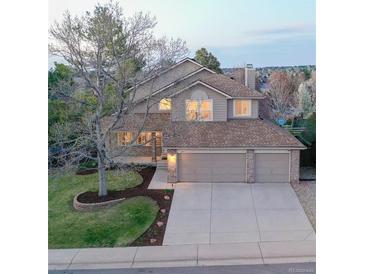 Charming two-story home with a three-car garage and well-manicured front lawn at 1431 Beacon Hill Dr, Highlands Ranch, CO 80126
