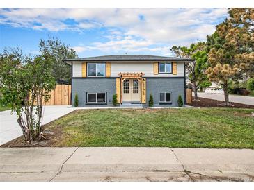 Charming home featuring a well-manicured lawn, modern exterior paint, and a pergola over the front door at 6775 Newland St, Arvada, CO 80003