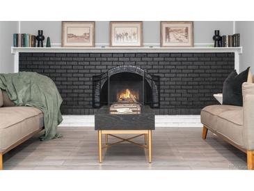 Cozy living room with a brick fireplace, mantle decor, and stylish coffee table at 7391 S Marion St, Centennial, CO 80122