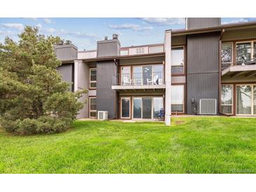 Multi-level townhouse featuring a grassy lawn, private balconies, and outdoor seating at 6515 Pinewood Dr, Parker, CO 80134
