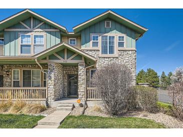 Inviting exterior of a two-story home featuring a stone facade and covered porch with craftsman details at 552 S Mobile Pl, Aurora, CO 80017