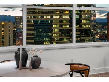 Modern dining area with a stunning city view from the large window at 1891 Curtis St # 1820, Denver, CO 80202