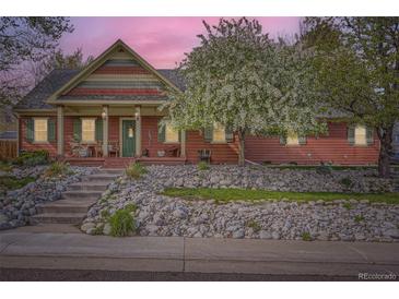 Charming single-Gathering home featuring a cozy front porch and colorful, well-maintained landscaping at 8801 W 65Th Ave, Arvada, CO 80004