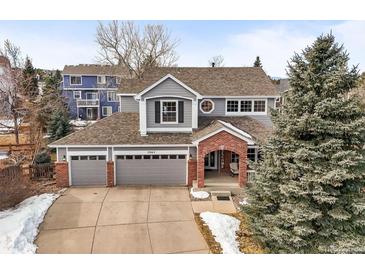 Charming two-story home with a three-car garage and inviting brick entryway at 7065 Campden Pl, Castle Pines, CO 80108