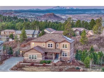 Beautiful two-story home with landscaped yard and stunning mountain views in the background at 5478 Water Oak Cir, Castle Rock, CO 80108