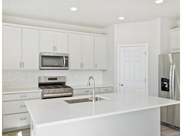 Modern kitchen with stainless steel appliances and white cabinetry at 8869 Sedalia St, Commerce City, CO 80022