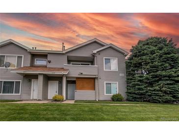 Inviting exterior showcasing a well-maintained townhouse with manicured lawn and covered balcony at 908 S Yampa St # 208, Aurora, CO 80017