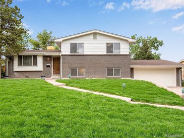 Charming brick home featuring a well-manicured lawn and inviting curb appeal at 13561 W Alaska Pl, Lakewood, CO 80228